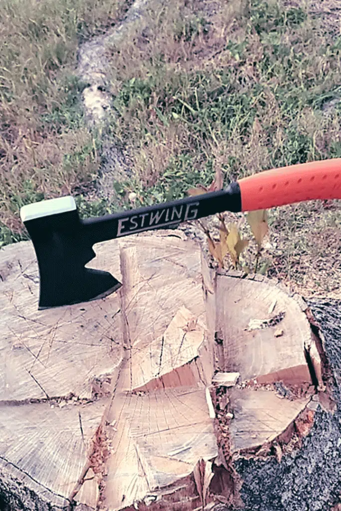 Estwing Camper's Axe with orange handle resting in a tree stump.